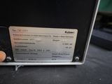 someone is pointing at a label on a machine that is sitting on top of a table