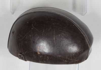 a brown helmet hanging on a white wall