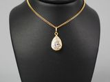 un collier en or avec un pendentif en forme de larme sur un mannequin