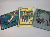 three children ' s books are lined up on a white surface