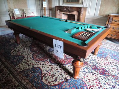 une table de billard recouverte d'un tapis vert, dans une pièce