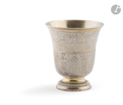 une coupe ancienne en argent posée sur un socle, sur fond blanc