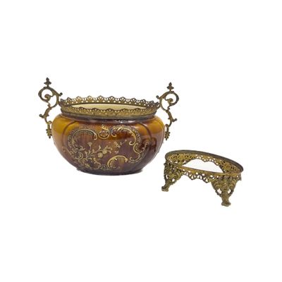 une image représentant un vase doré et marron posé sur un socle