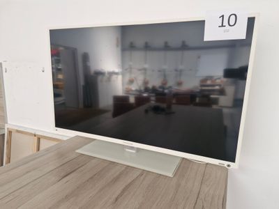 une télévision à écran plat posée sur une table en bois