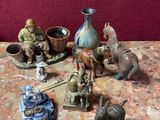 de nombreuses figurines posées sur une table à côté d'un vase