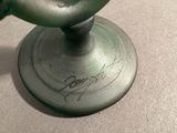 a close up of a green candle holder on a table
