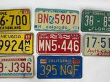 several different license plates are arranged in a row on a table