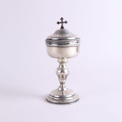 une image représentant une coupe en argent surmontée d'une croix