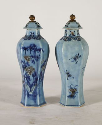 pair of blue and white vases sitting on top of a white table