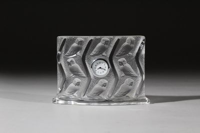 une horloge en verre posée sur une table