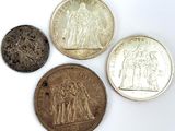 quatre types de pièces différents posés sur une surface blanche