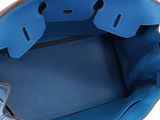 the inside of a blue handbag with a brown handle