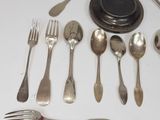 a lot of silver spoons and forks on the table
