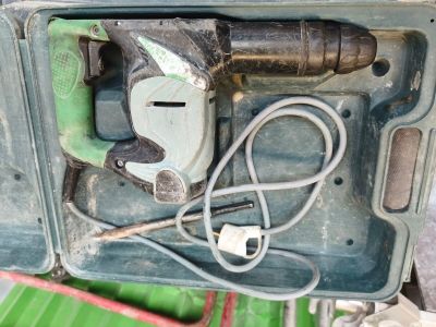 a green box with a drill and a cord in it
