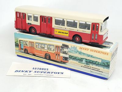 un bus rouge et blanc posé sur une boîte
