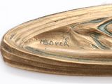 a close up of a gold plate with a bird on it