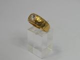 a close up of a gold ring with a diamond on it