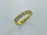une bague en or jaune sertie de cinq diamants sur fond blanc