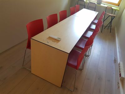 a long table with red chairs in a room