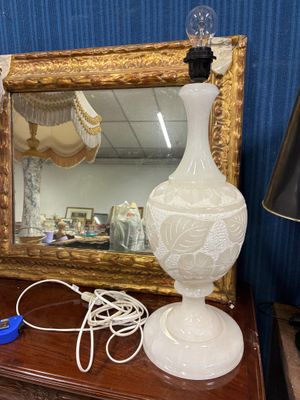 une lampe posée sur une table à côté d'un miroir