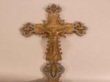 a gold cross with a blue and white design on it