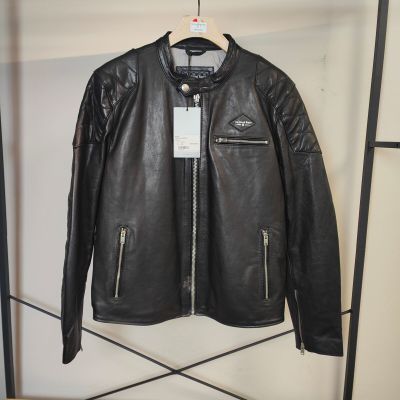 une veste en cuir noir accrochée à un portant dans un magasin