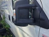 a white van parked in the grass next to a tree