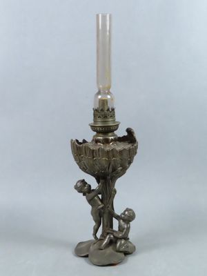 an antique silver plated candle holder with a boy holding a candle