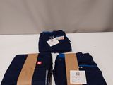 trois pantalons bleus posés sur une table blanche