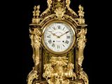a gold clock sitting on top of a marble table
