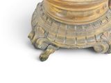 a gold vase that is sitting on a white surface