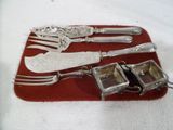 argenterie sur un plateau rouge sur une table blanche