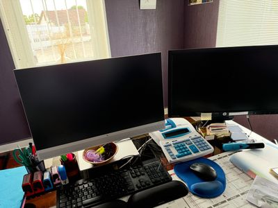a desk with two computer monitors and a keyboard on it