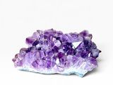 un gros plan sur un amas de cristaux violets posés sur une surface blanche