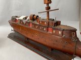 a wooden model of a boat on display on a table
