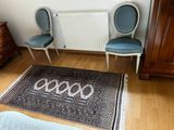 two chairs and a rug on the floor in a room