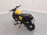 a yellow and black motorcycle parked in a white room