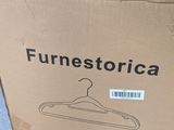 a person holding a cardboard box with a clothes hanger on it
