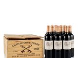 six bottles of wine in a wooden box on a white surface