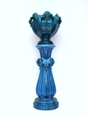 a blue vase sitting on top of a table