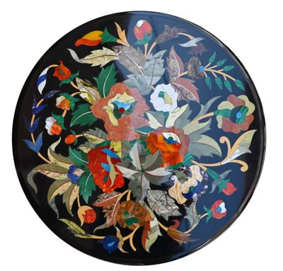 une assiette noire ornée de fleurs et de feuilles colorées
