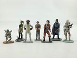 the figurines of star wars characters are lined up on a white surface