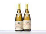 two bottles of white wine sitting next to each other on a table