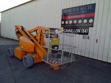 a picture of a small orange scissor parked in front of a building