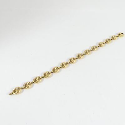 gros plan d'un bracelet en chaîne en or sur fond blanc