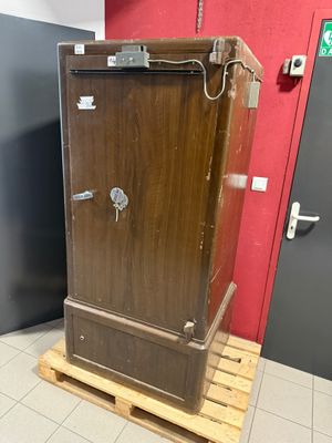 a wooden cabinet that is on a pallet in a room