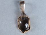 a picture of a pendant with a black stone on it