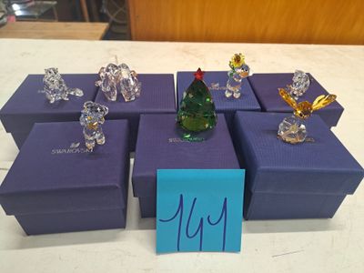 purple boxes with glass figurines on top of them on a table