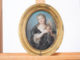 un tableau représentant une femme tenant un oiseau, dans un cadre doré