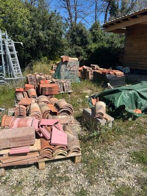 de nombreuses casseroles et poêles posées par terre devant un immeuble